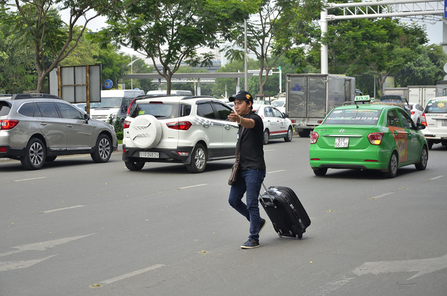 Nhiều người k&eacute;o vali đi bộ v&agrave;o s&acirc;n bay để kịp l&agrave;m thủ tục l&ecirc;n chuyến bay
