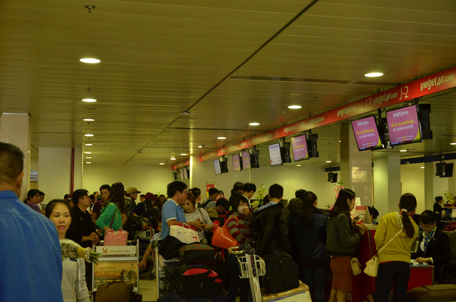 Người d&acirc;n xếp h&agrave;ng l&agrave;m thủ tục để l&ecirc;n m&aacute;y bay trưa 24/1