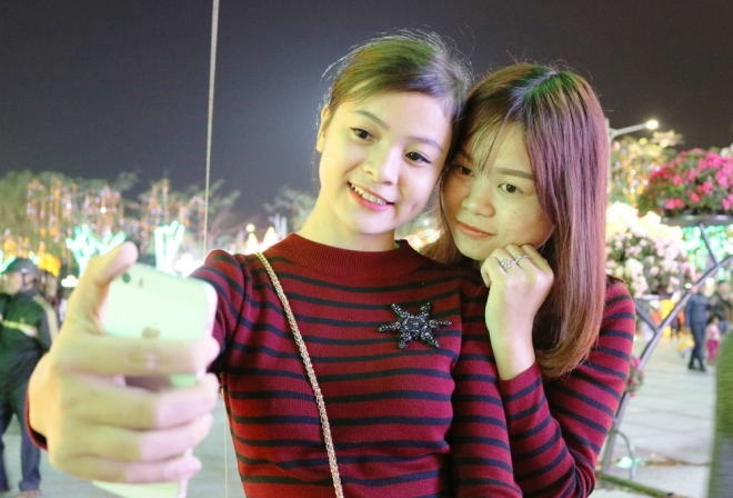 Thiếu nữ đất Cảng chụp h&igrave;nh lưu niệm ở quảng trường trung t&acirc;m.