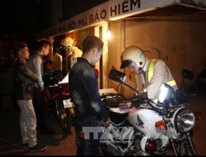Lực lượng c&ocirc;ng an Tổ c&ocirc;ng t&aacute;c 141 xử phạt người điều khiển xe m&aacute;y vi phạm Luật Giao th&ocirc;ng đường bộ đ&ecirc;m giao thừa. Ảnh: Do&atilde;n Tấn/TTXVN