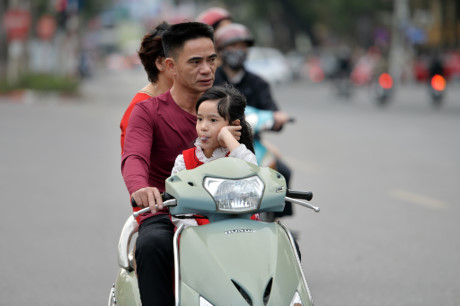 Một gia đ&igrave;nh cả ba th&agrave;nh vi&ecirc;n kh&ocirc;ng đội mũ bảo hiểm.