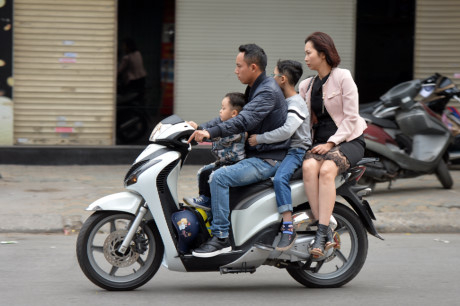 Một gia đ&igrave;nh để mũ bảo hiểm dưới ch&acirc;n.