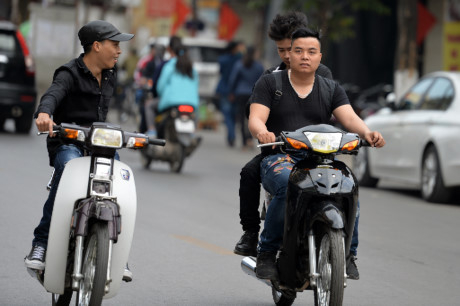 Thanh ni&ecirc;n đội mũ mềm vừa đi vừa t&aacute;n chuyện với người đi xe song song.