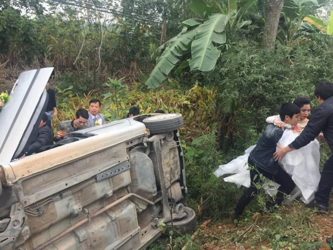 Họ h&agrave;ng nhanh ch&oacute;ng đến giải cứu c&ocirc; d&acirc;u, ch&uacute; rể, t&agrave;i xế ra khỏi chiếc xe gặp nạn.