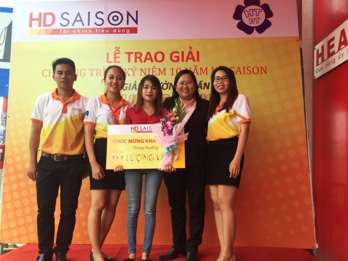 Chị L&ecirc; Thị Th&ugrave;y Tr&acirc;n (&aacute;o đỏ) may mắn nhận được 1 lượng v&agrave;ng SJC từ HD Saison