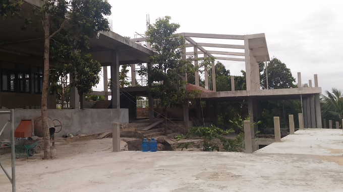 Một c&ocirc;ng tr&igrave;nh nh&agrave; nhiều tầng ki&ecirc;n cố mọc l&ecirc;n gần đỉnh n&uacute;i.