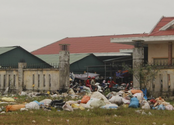 R&aacute;c thải được cho v&agrave;o bao tải tạo th&agrave;nh đống trước cổng chợ.