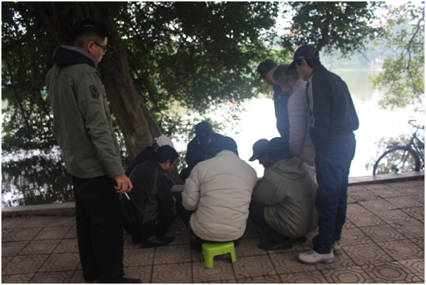 Ở một g&oacute;c hồ Gươm nhiều người đang co ro đ&aacute;nh cờ.