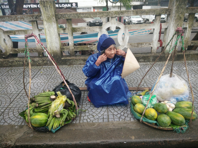 Cầu Tr&agrave;ng Tiền, cụ b&agrave; b&aacute;n h&agrave;ng chống chọi với gi&aacute; lạnh. (Ảnh: Như Quỳnh)