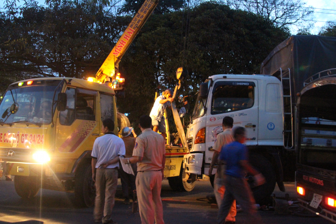 Xe cẩu n&acirc;ng b&aacute;nh xe tải mới đưa được thi thể nữ c&ocirc;ng nh&acirc;n ra ngo&agrave;i.