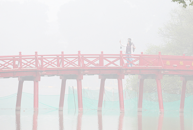 Kh&aacute;ch du lịch dậy sớm chụp h&igrave;nh lưu niệm tr&ecirc;n cầu Th&ecirc; H&uacute;c trong m&agrave;n sương mờ ảo.