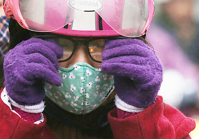 Người phụ nữ lau k&iacute;nh khi dừng đ&egrave;n đỏ ở ng&atilde; tư T&ocirc;n Đức Thắng.