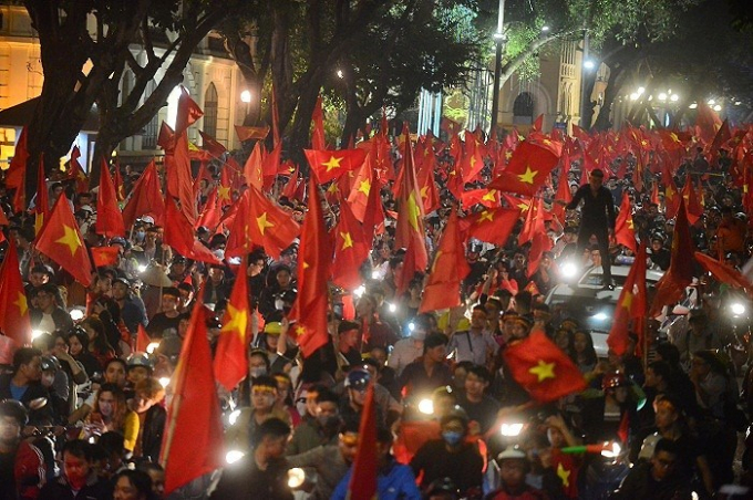 C&oacute; những cổ động vi&ecirc;n vui mừng, đứng l&ecirc;n cả n&oacute;c &ocirc; t&ocirc; để vẫy cờ.