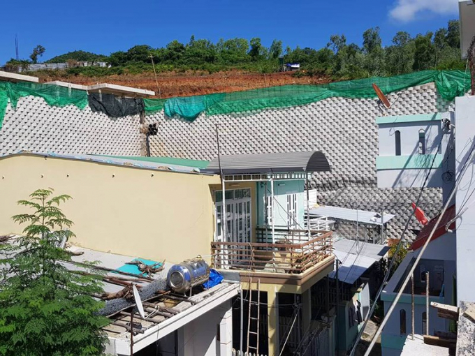 Tường th&agrave;nh khổng lồ nằm tr&ecirc;n sườn n&uacute;i, ngay tr&ecirc;n đầu nh&agrave; d&acirc;n.