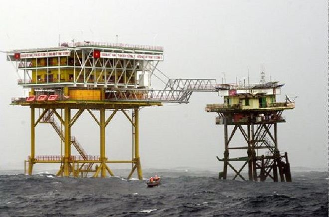 Xuồng m&aacute;y của t&agrave;u Trường Sa 19 chạy v&agrave;o s&aacute;t ch&acirc;n đế nh&agrave; gi&agrave;n DK1/14 để c&aacute;c chiến sĩ tr&ecirc;n gi&agrave;n k&eacute;o qu&agrave; Tết l&ecirc;n bằng d&acirc;y r&ograve;ng rọc