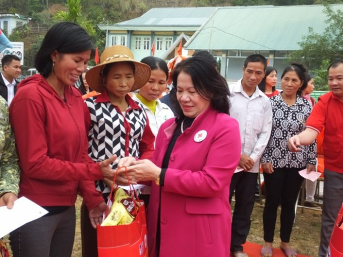 B&agrave; Nguyễn Thị Xu&acirc;n Thu - Chủ tịch Trung ương Hội Chữ thập đỏ Việt Nam trao qu&agrave; cho b&agrave; con bản Chiềng.