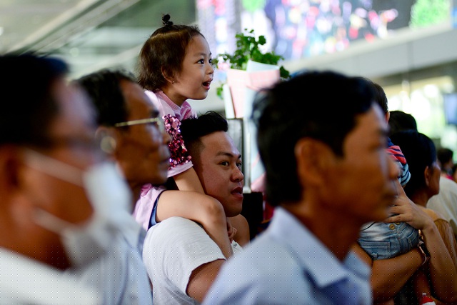 Em bé được bố cõng trên vai để tránh đông đúc.