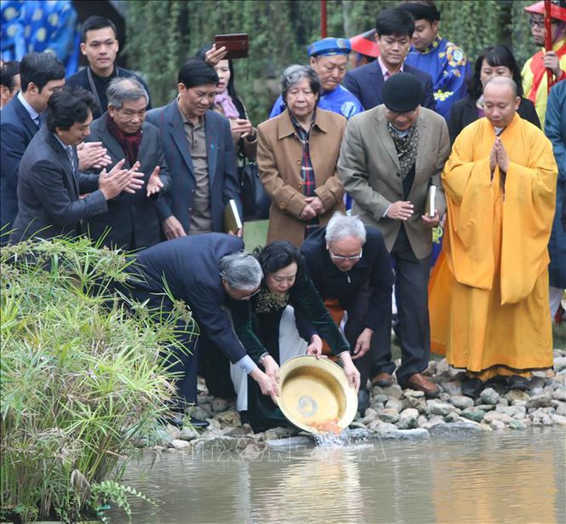 Đoàn hành lễ thả cá chép tại khu vực dòng sông cổ. Ảnh: Thanh Tùng/TTXVN