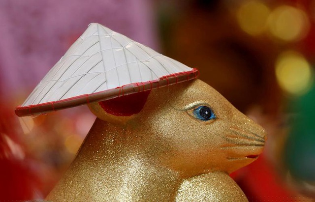 Tượng con chuột, con giáp của năm nay, đội nón trong một cửa tiệm bán đồ Tết ở Hà Nội, Việt Nam.