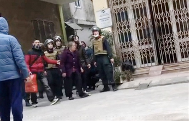 Nghi can Trần Thị Đàm được dẫn ra ngoài để đưa lên xe đặc chủng