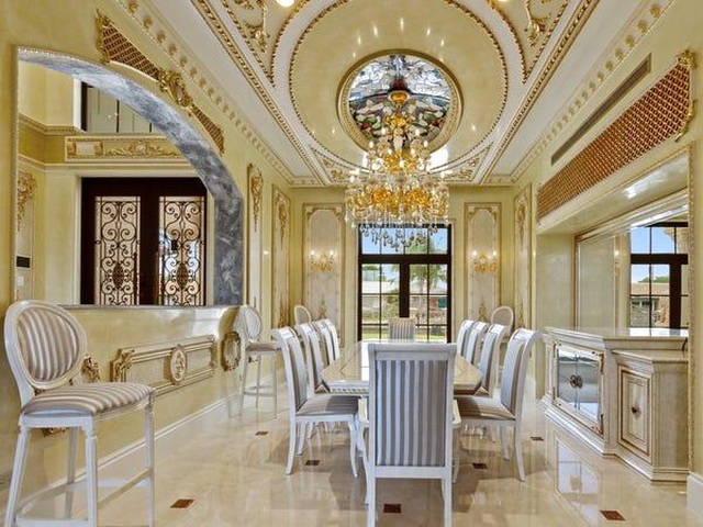 Bàn ăn đủ chỗ cho 10 người ngồi, được đặt giữa không gian như trong cung điện với bộ đèn chùm đắt tiền cùng các bức tường có màu vàng, chạm trổ tinh xảo xung quanh. Với nét lộng lẫy đó, phòng ăn này hoàn toàn phù hợp để mở các bữa tiệc sang trọng.