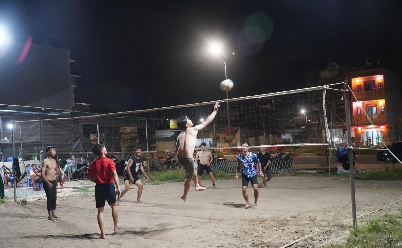 Thanh ni&ecirc;n trong khu t&aacute;i định cư đ&aacute;nh b&oacute;ng chuyền tại một b&atilde;i đất trống.