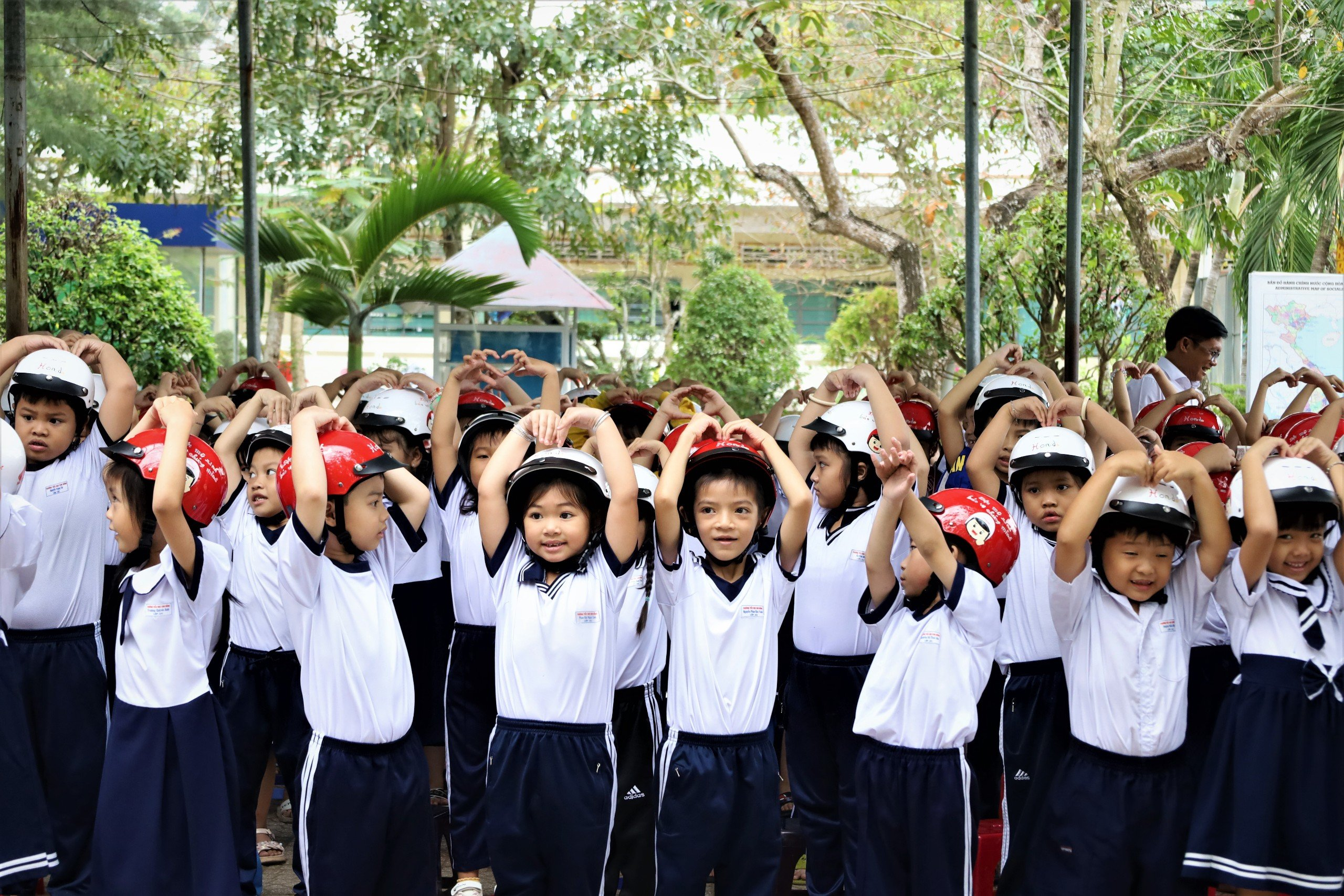 Niềm vui của các em học sinh khi được tặng mũ bảo hiểm từ chương trình “An toàn cho em - niềm vui gia đình”.