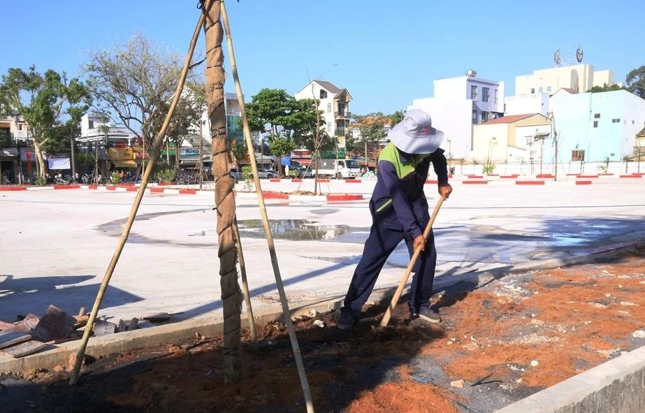 Công nhân đang hoàn thành phần việc trồng và chăm sóc cây xanh trong khuôn viên bãi đậu xe.