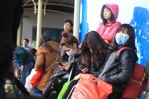 Do đợi chờ qu&aacute; l&acirc;u, những bạn trẻ đ&atilde; t&igrave;m đến chiếc điện thoại để giải tr&iacute;.&nbsp;Ảnh: Như Trường.