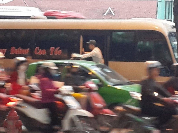 Phụ xe nho&agrave;i người ra ngo&agrave;i, ch&egrave;o k&eacute;o kh&aacute;ch ngay giữa l&ograve;ng đường.