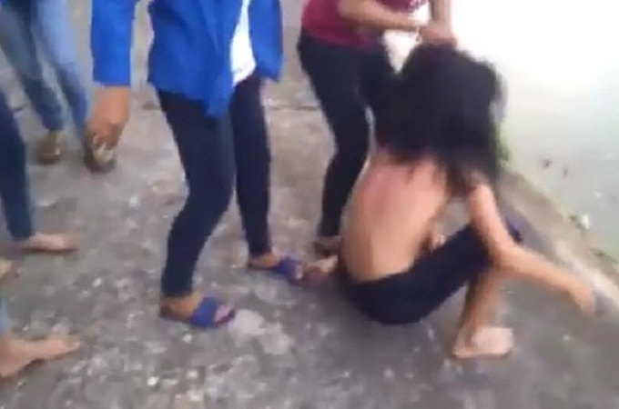 Nh&oacute;m người h&agrave;nh hung cố đẩy c&ocirc; g&aacute;i xuống hồ.