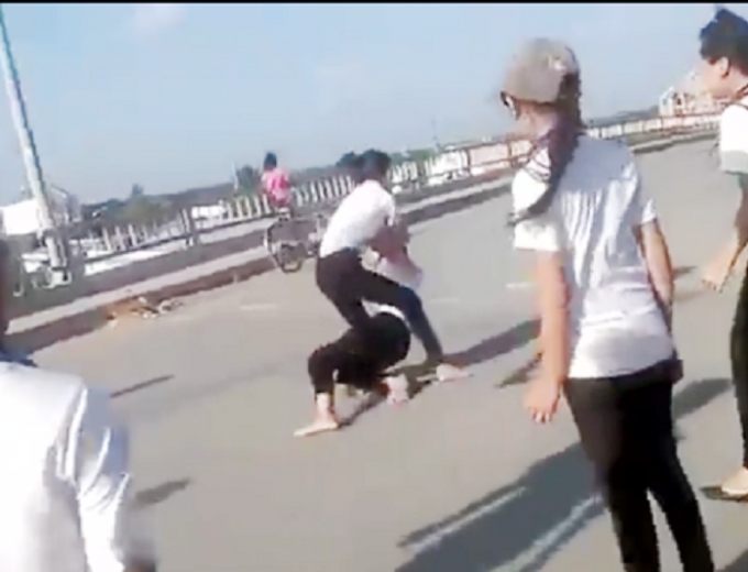 Hai nữ sinh đ&aacute;nh nhau c&oacute; sự cổ vũ của nhiều học sinh kh&aacute;c.