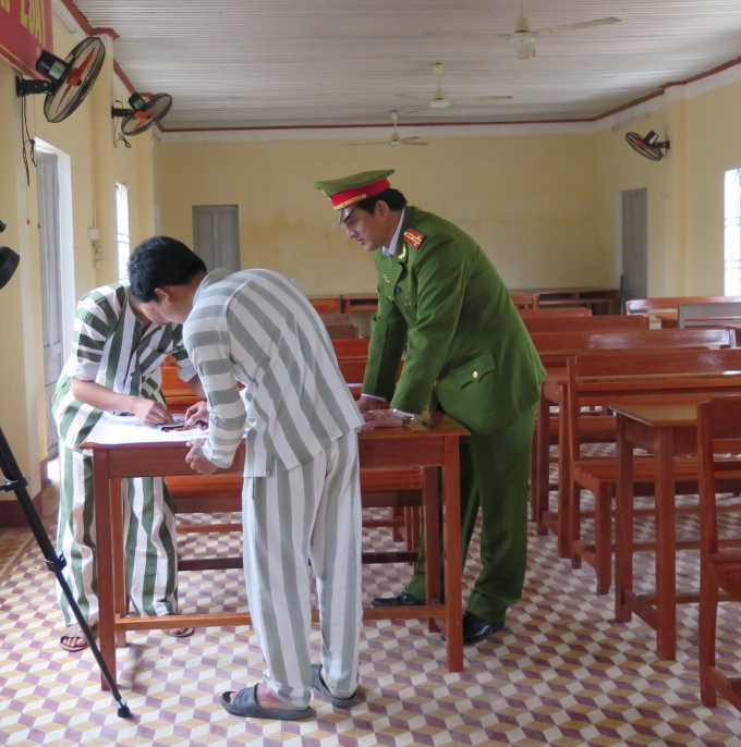 Thượng t&aacute; Nguyễn Th&agrave;nh Nh&acirc;n - Gi&aacute;m thị trại giam đang hướng dẫn phạm nh&acirc;n&nbsp;l&agrave;m b&aacute;o tường&nbsp;(ảnh: Phương Nam).