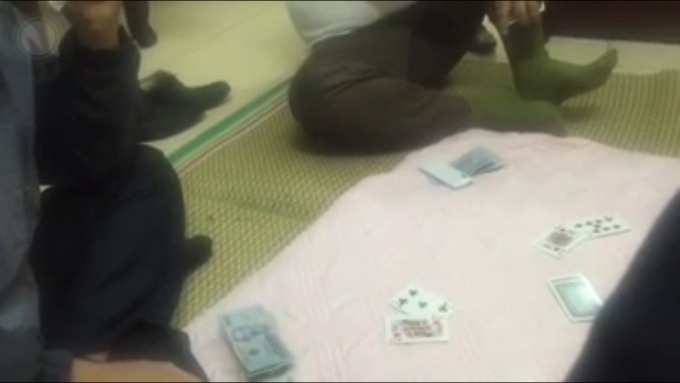 Đoạn clip quay lại được cảnh 4 người đ&agrave;n &ocirc;ng ngồi đ&aacute;nh bạc trong trụ sở. (Ảnh: Cắt từ clip).