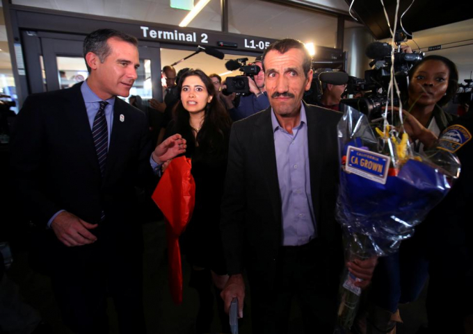 Thị trưởng Los Angeles Eric Garcetti (b&ecirc;n tr&aacute;i) dẫn đường cho anh Ali Vayeghan v&agrave; ch&aacute;u g&aacute;i Marjan Vayeghan, người Iran ra khỏi s&acirc;n bay. Anh Ali l&agrave; người đầu ti&ecirc;n được trở lại Mỹ nhờ quyết định của t&ograve;a &aacute;n li&ecirc;n bang California.