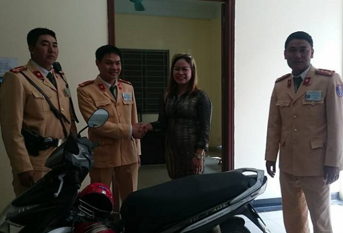 C&aacute;c chiến sĩ CSGT Đội 2 b&agrave;n giao chiếc xe m&aacute;y cho chị Nguyễn Thị Hưng.