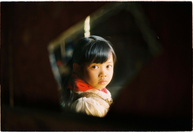 Một em b&eacute; soi m&igrave;nh trong tấm gương vỡ, m&oacute;n đồ chỉnh đốn trang phục của cả gia đ&igrave;nh.