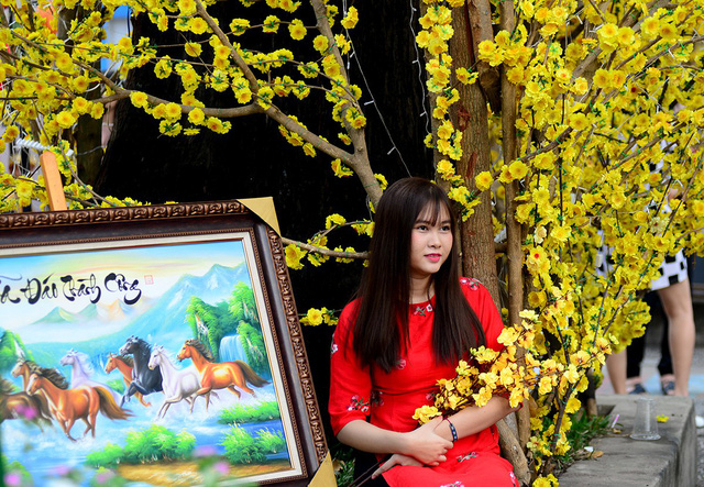 Thiếu nữ thu&ecirc; cả thợ chụp h&igrave;nh để chụp h&igrave;nh với hoa.