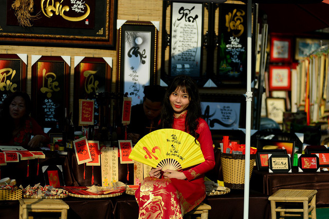 Thiếu nữ b&ecirc;n quầy viết thư ph&aacute;p của &ocirc;ng đồ.