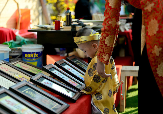 B&eacute; trai t&ograve; m&ograve; với những bức tranh ở gian h&agrave;ng phố &ocirc;ng đồ.