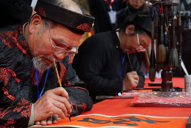 Trong ng&agrave;y khai mạc, phố &ocirc;ng đồ c&ograve;n nhiều &ocirc; trống nhưng đ&atilde; c&oacute; kh&aacute; đ&ocirc;ng người đến tham quan, xin chữ.