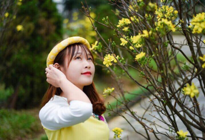 Thiếu nữ ngắm hoa Xu&acirc;n đang khoe sắc.