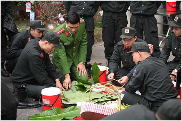 C&aacute;n bộ hướng dẫn c&aacute;c đo&agrave;n vi&ecirc;n g&oacute;i b&aacute;nh chưng.