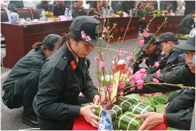 Nữ cảnh s&aacute;t cơ động kh&eacute;o l&eacute;o ho&agrave;n thiện chiếc b&aacute;nh chưng.