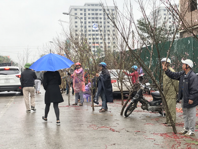 Nhiều người dầm mưa, chịu c&aacute;i lạnh t&ecirc; t&aacute;i ra tận lề đường để b&aacute;n đ&agrave;o tết