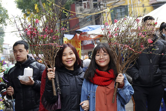 Vẻ phấn khởi của những vị kh&aacute;ch mua được c&agrave;nh đ&agrave;o vừa &yacute; trong chợ hoa H&agrave;ng Lược.