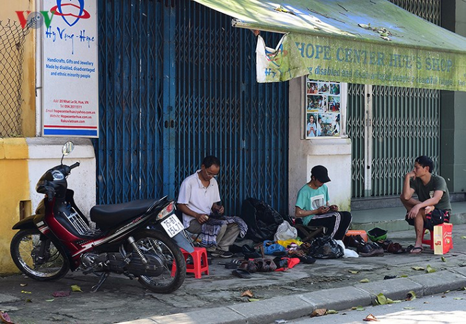 Những người thợ sửa gi&agrave;y đang đ&aacute;nh xi gi&agrave;y cho những kh&aacute;ch h&agrave;ng cuối c&ugrave;ng trong năm.