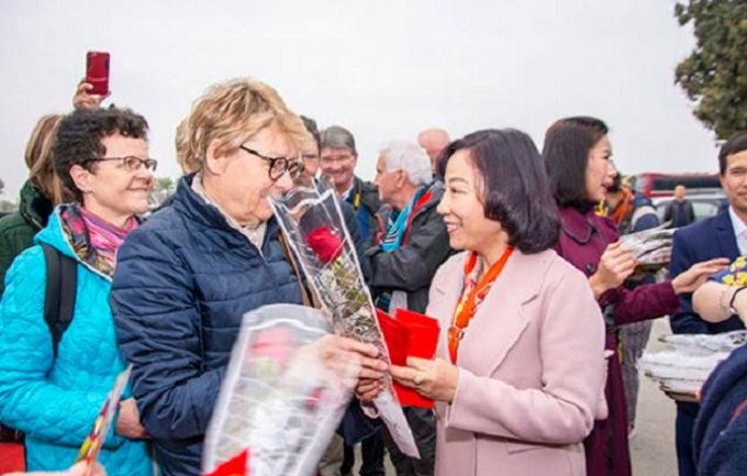 Ba Vũ Thị Thu Thủy trao hoa v&agrave; l&igrave; x&igrave; mừng tuổi những du kh&aacute;ch đầu ti&ecirc;n đến với Vịnh Hạ Long trong ng&agrave;y m&ugrave;ng 1 tết &acirc;m lịch.