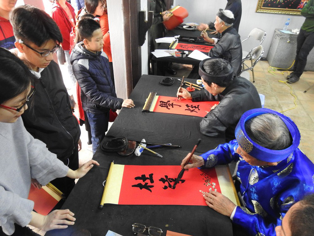 Nhiều sĩ tử xin chữ trong s&aacute;ng m&ugrave;ng 1 Tết Mậu Tuất cầu mong được đỗ đạt. (ảnh: Đ&igrave;nh Cường)