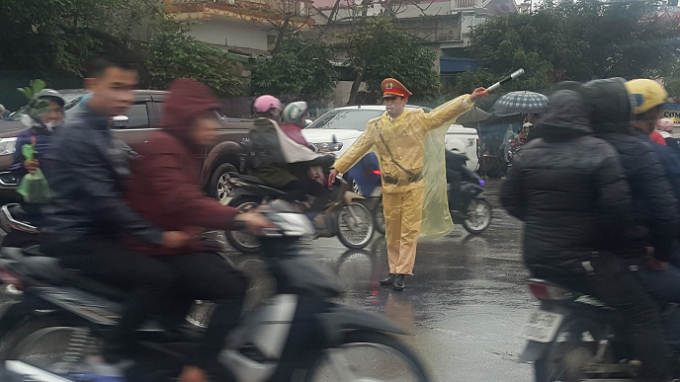 Lực lượng CSGT gồng m&igrave;nh đội mưa ph&acirc;n luồng giao th&ocirc;ng tại c&aacute;c tuyến đường giao cắt g&acirc;y &ugrave;n tắc.
